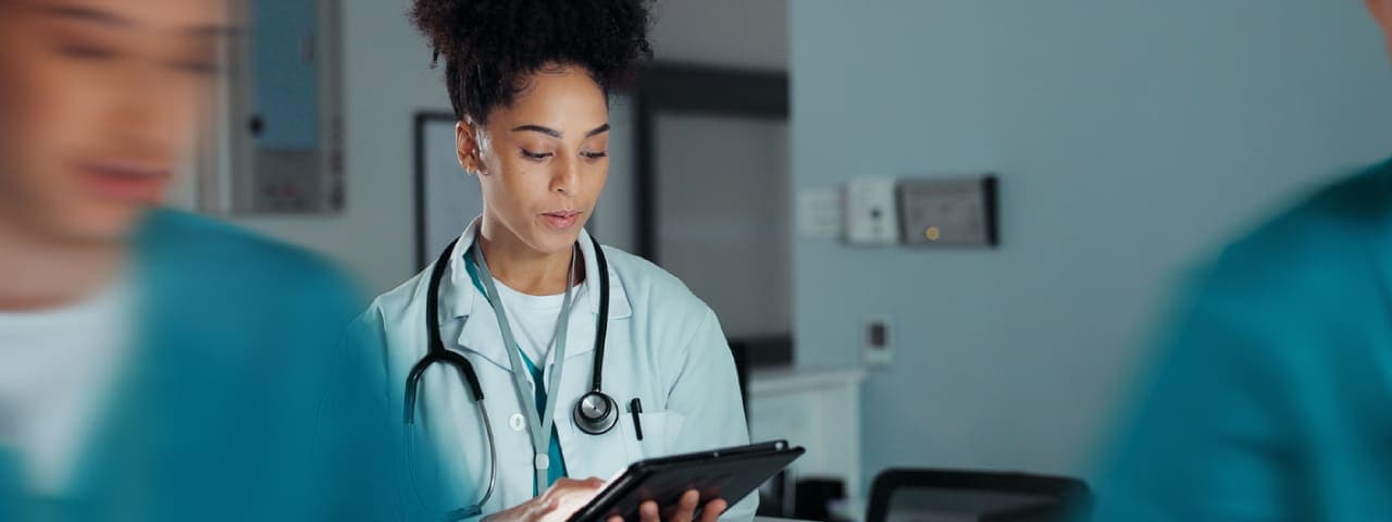A female healthcare worker looking at a tablet