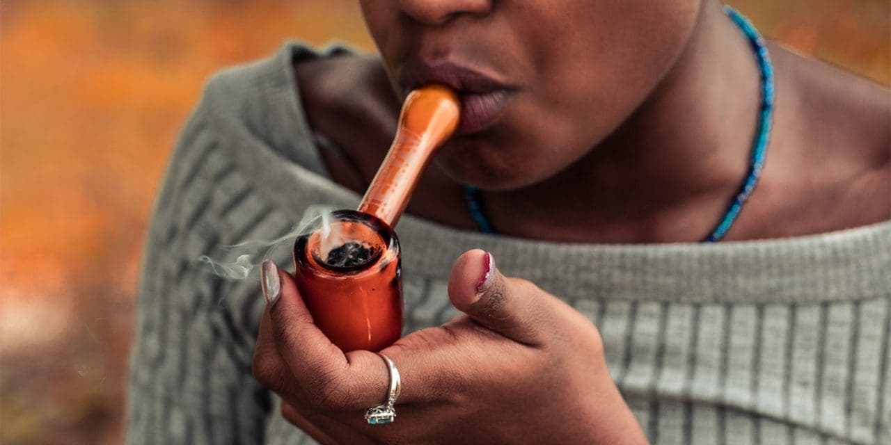 smoking weed using wood pipe